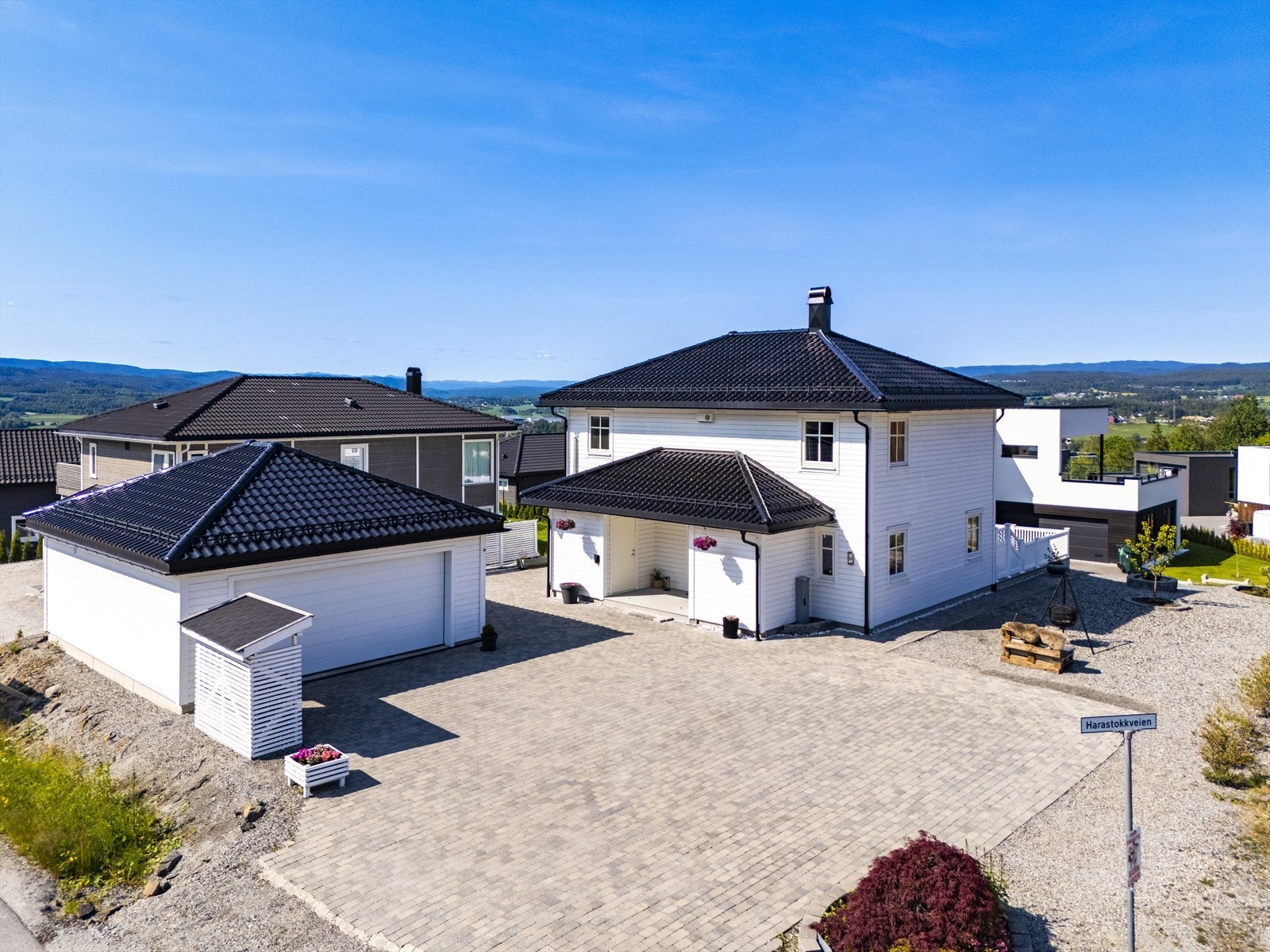 Romslig brosteinsbelagt gårdsplass med gode parkeringsforhold. Det er også satt opp dobbelgarasje på ca. 47m2. Galleribilde