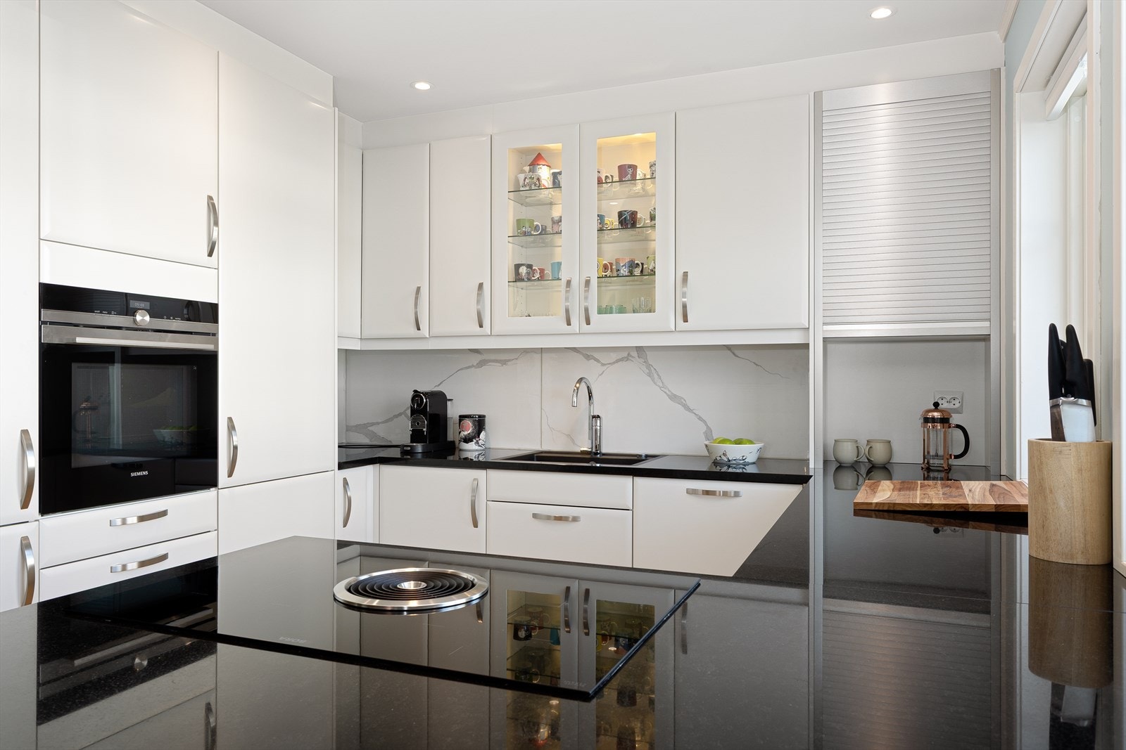 Integrerte hvitevarer som stekeovn, platetopp med innebygget ventilator, oppvaskmaskin og kjøl/frys. Galleribilde