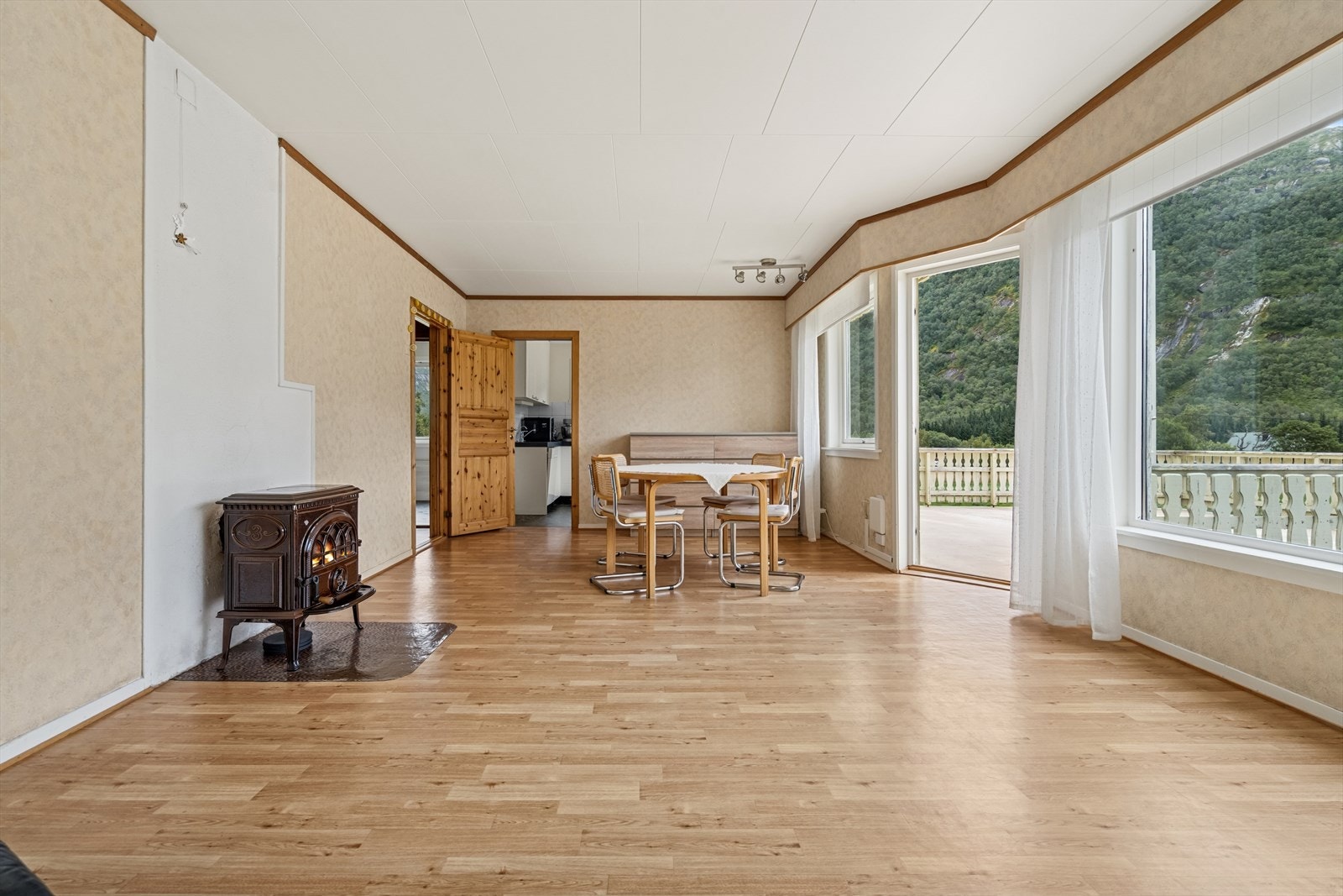 Videre inn i boligen kommer du til en romslig stue, med store vindusflater som slipper inn mye naturlig lys og gir en luftig atmosfære. Galleribilde