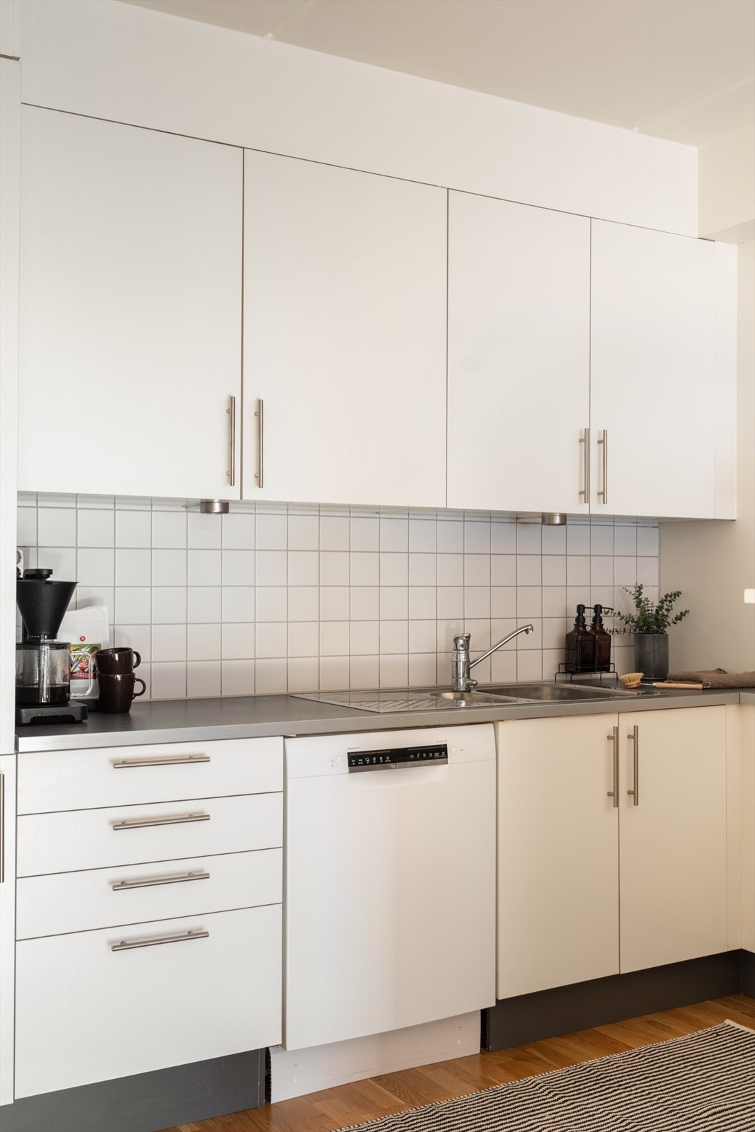 Kjøkken med lyse, stilrene flater som gir et tidløst uttrykk. Galleribilde