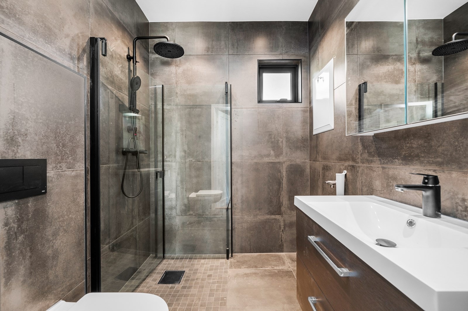 Pent innredet flislagt bad med opplegg for vaskemaskin. Galleribilde