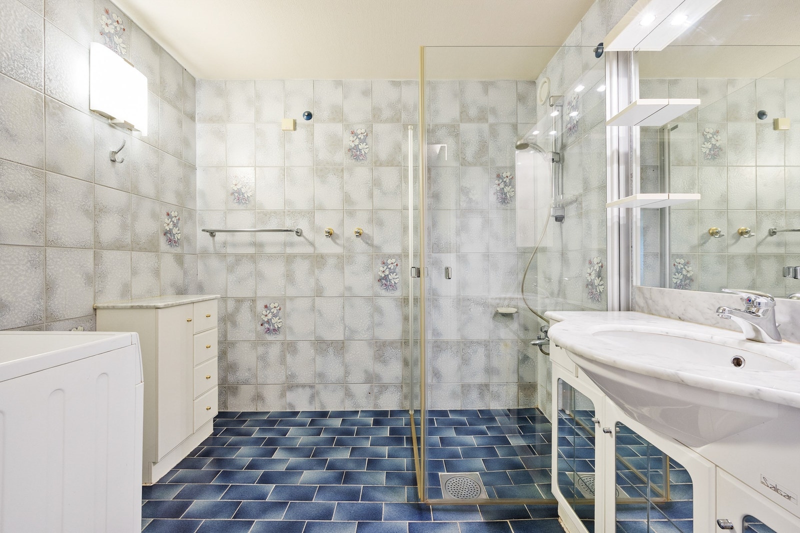 Badet er innredet med benkeskap og servant med belysning. Galleribilde