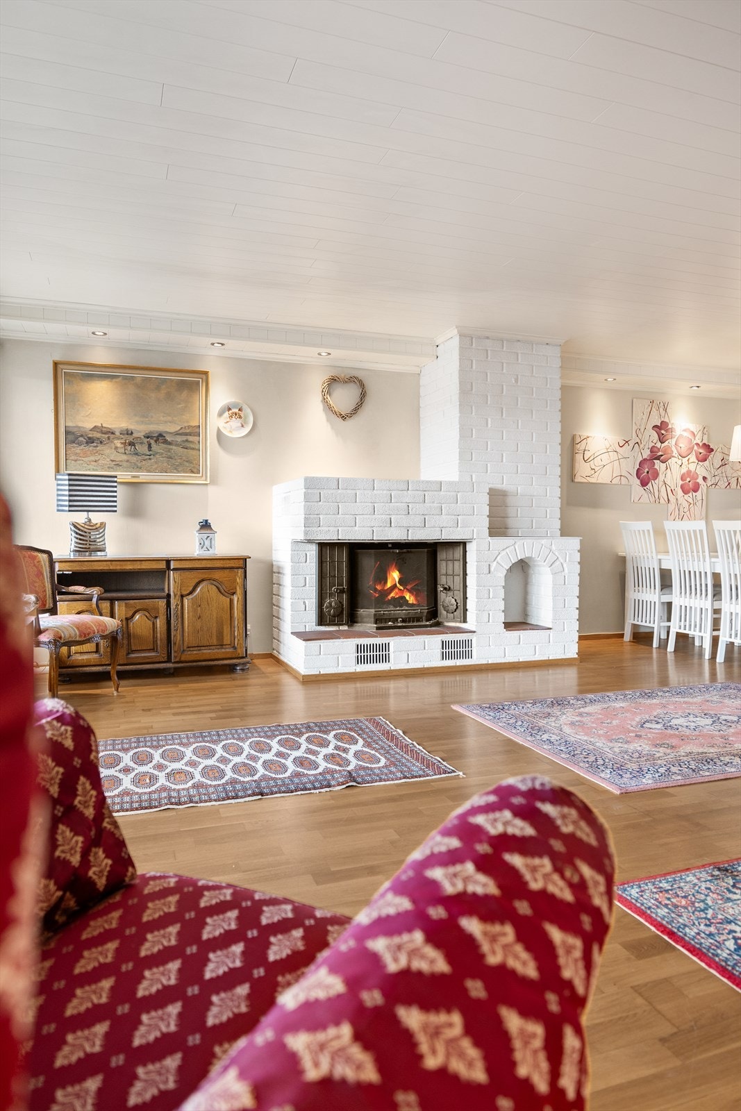 Flott peis i malt teglstein som bidrar til varme og en hyggelig atmosfære i hele leiligheten Galleribilde