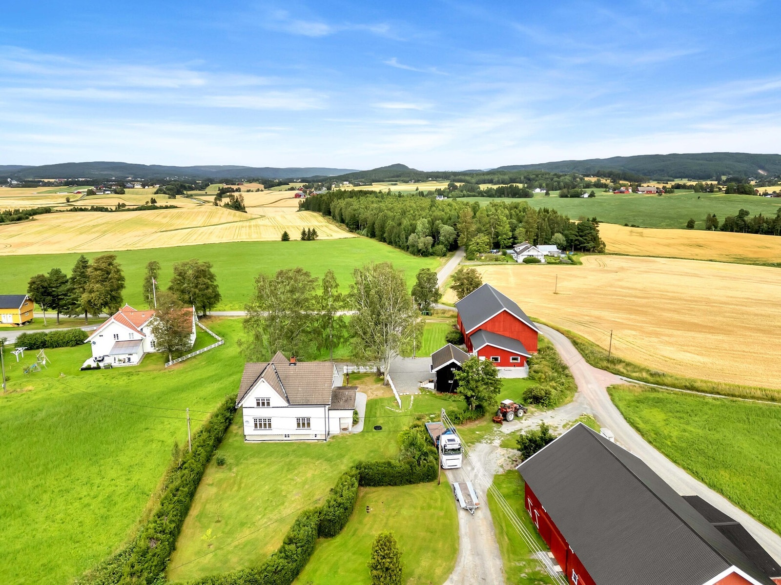 Tomten ved huset er pent opparbeidet med gressplen, store trær, diverse beplantning og stemningsfull belysning langs en gruslagt gangvei. Galleribilde