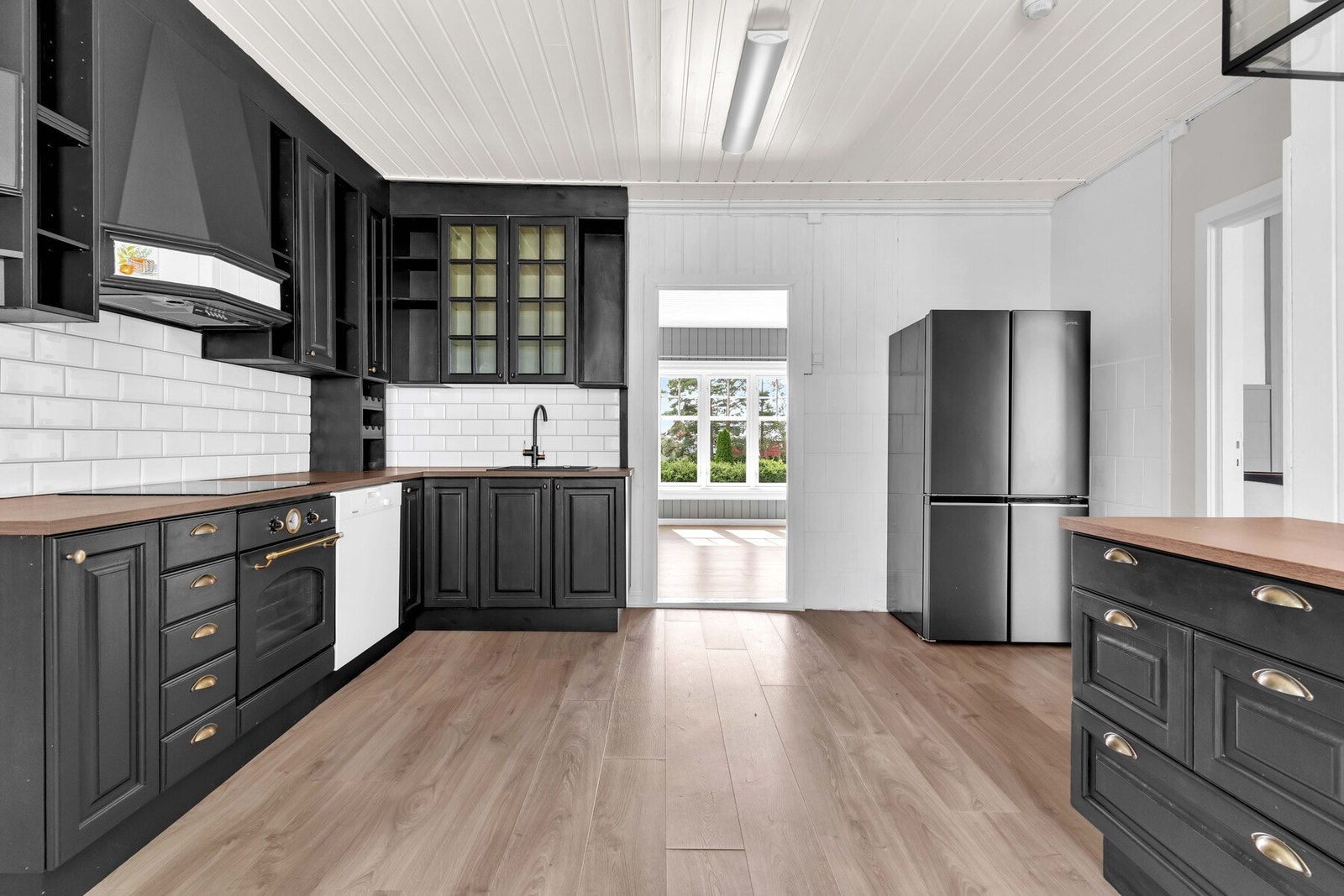 Over benken er det hvite metrofliser, og over kokesonen er en hetteventilator installert. Galleribilde