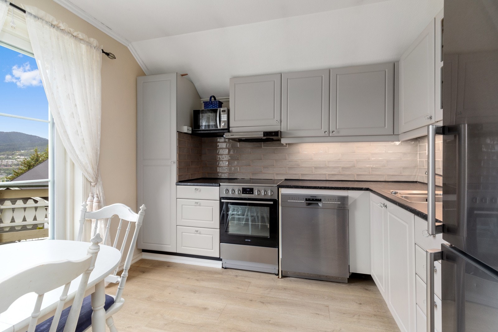 Kjøkken har under- og overskap med utgang til romslig balkong. Store vindusflater gir rommet rikelig med naturlig lys. Galleribilde