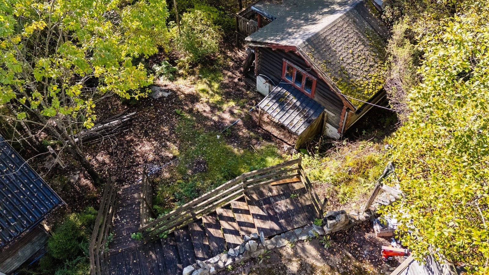 Adkomst til hytten via en tretrapp fra 2006, som leder ned fra en støttemur. Galleribilde