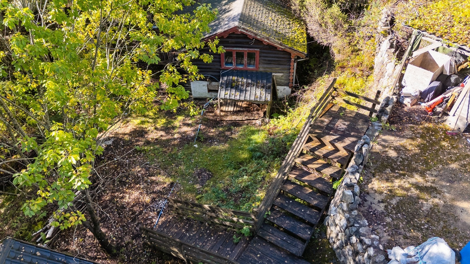 Eiendommen ligger usjenert til på en kupert tomt, omgitt av trær og natur. Galleribilde
