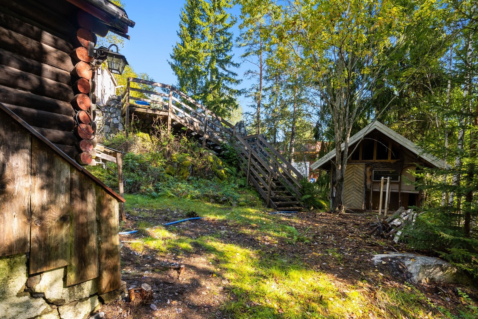 En tretrapp forbinder de ulike nivåene på tomten og leder ned til hytteområdet. Galleribilde