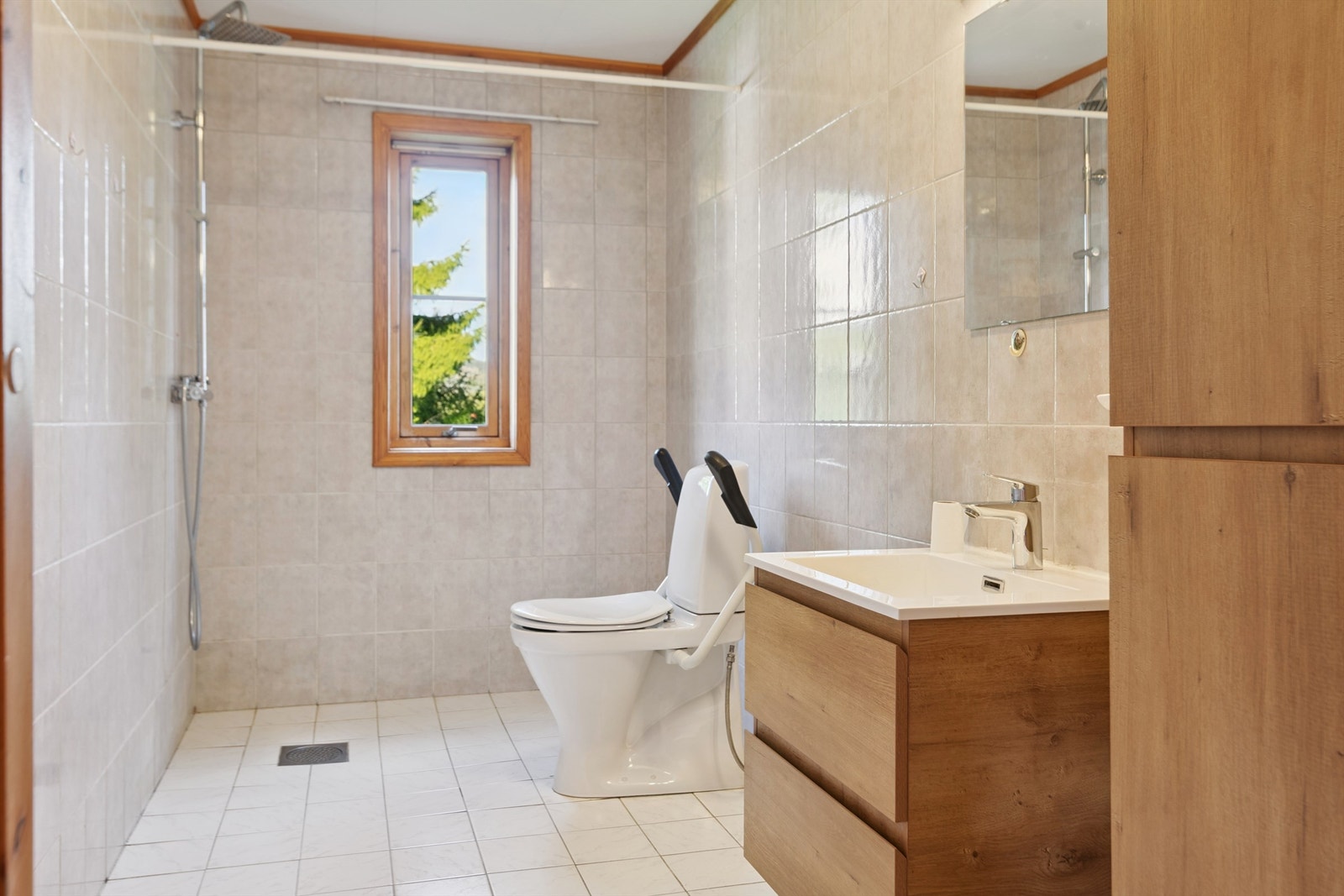 Badet i første etasje er flislagt og utstyrt med dusjhjørne og en ny servantinnredning fra 2024. Galleribilde
