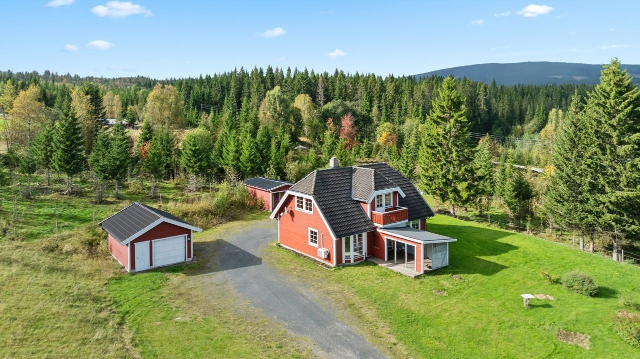 Eiendommen omfatter enebolig, garasje og carport med bod, plassert i naturskjønne omgivelser. Galleribilde