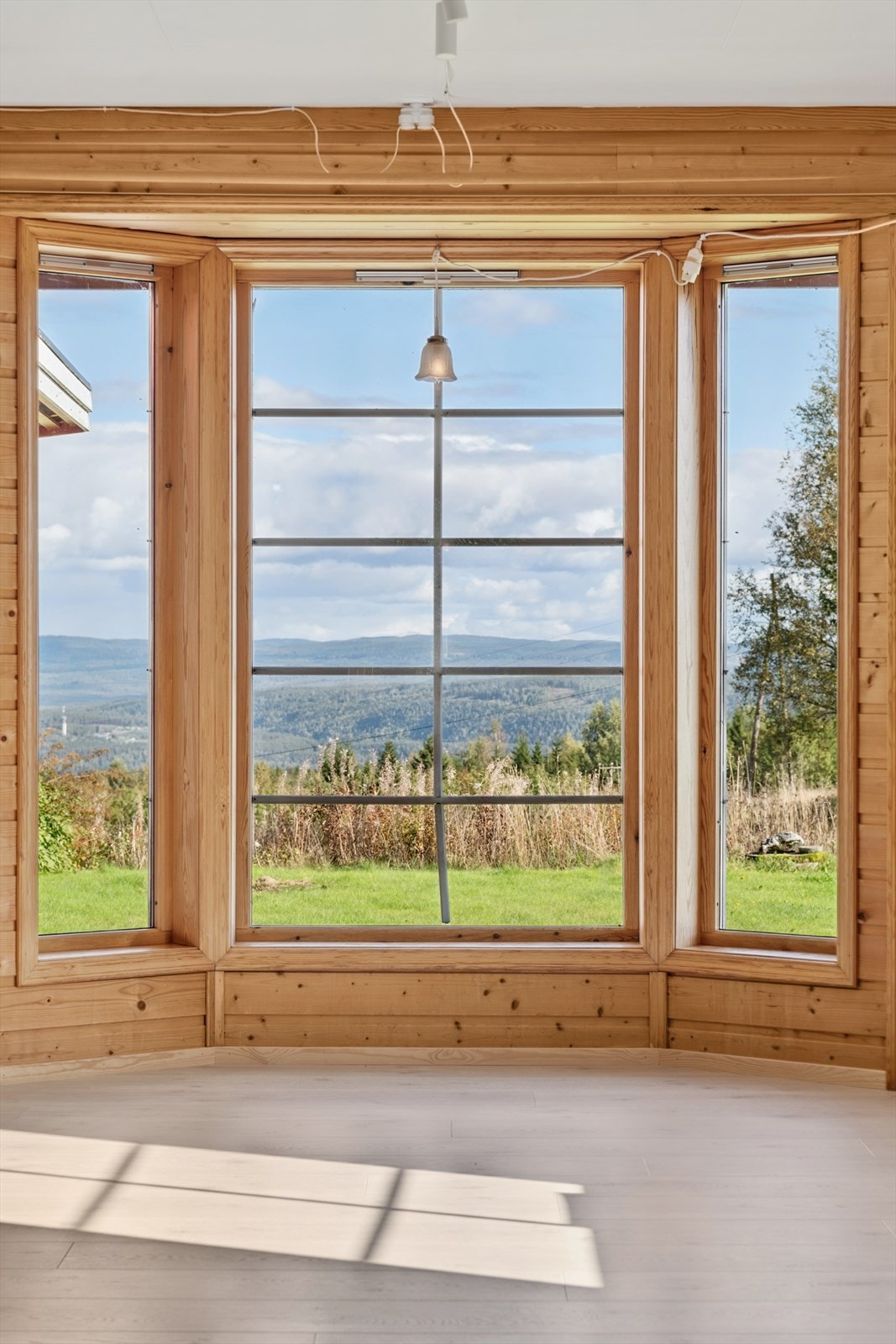 Karnappvinduet i stuen rammer inn utsikten over det omkringliggende landskapet. Galleribilde