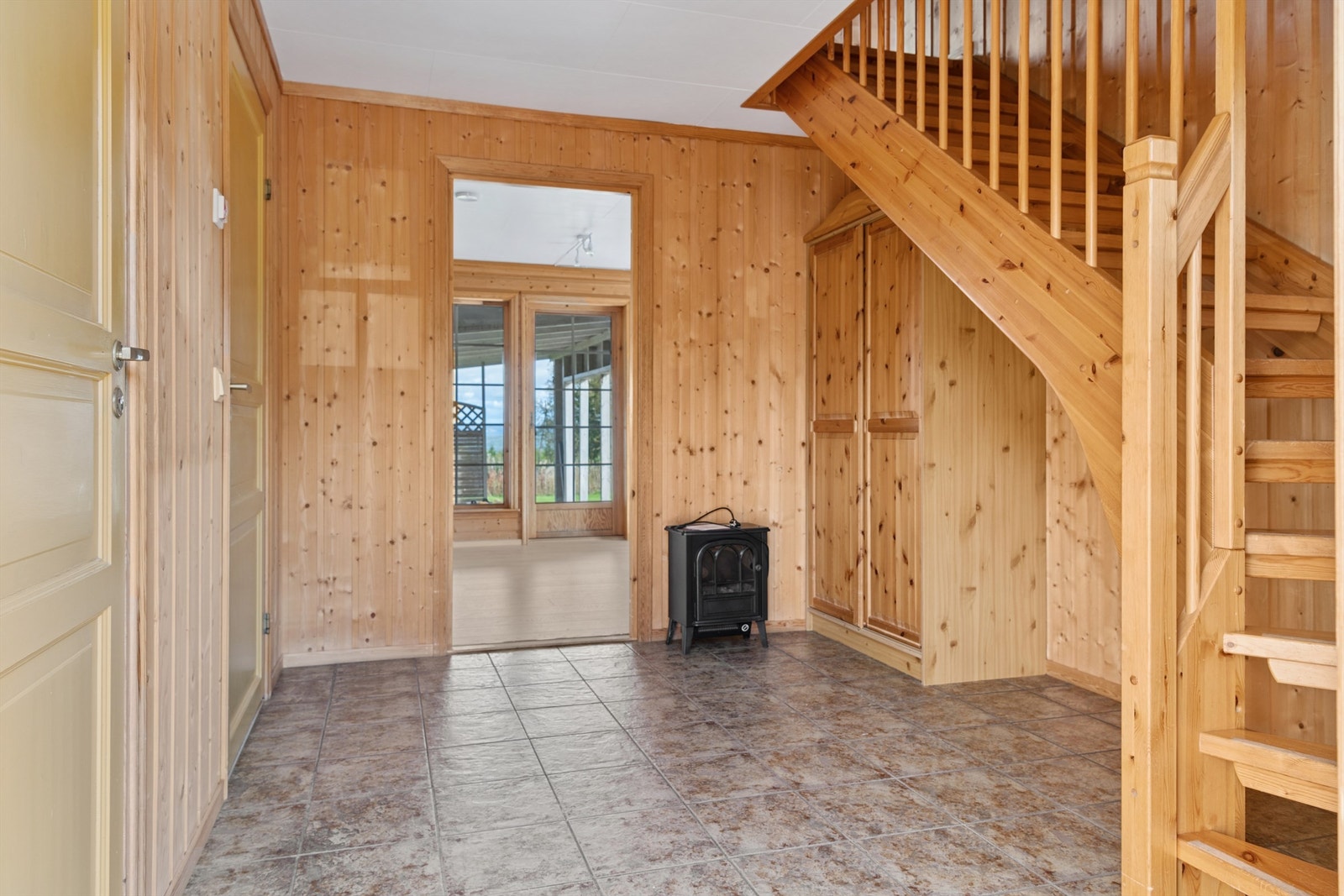 Velkommen inn i en hall med elektrisk gulvvarme og trapp som leder opp til andre etasje. Galleribilde