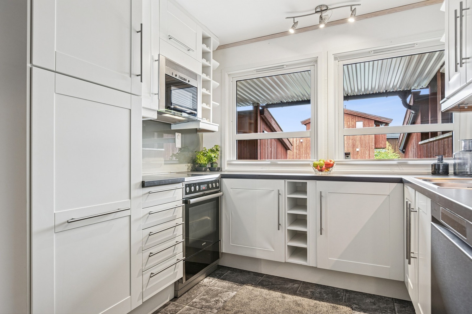 Lyst og tidløst kjøkken som er godt utstyrt med skap-, skuff- og benkeplass. Galleribilde