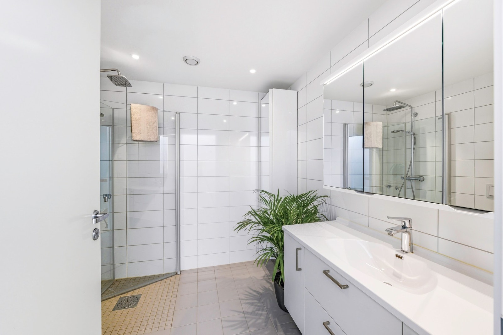 Moderne og stilrent bad på ca. 5,5 kvm med varmekabler i gulv og opplegg for vaskemaskin. Galleribilde