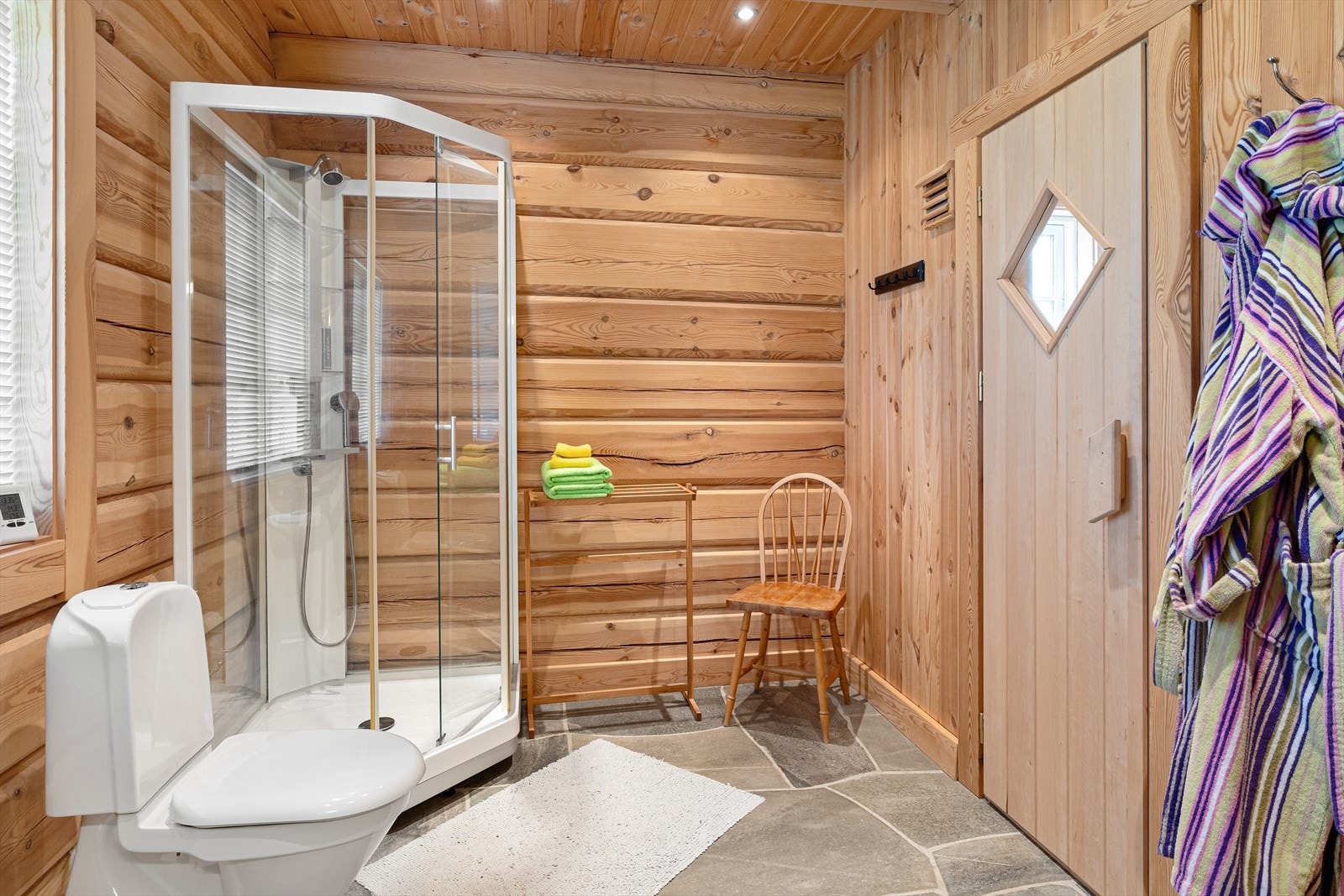 Badet inneholder innredning med servant, toalett, dusjkabinett og badstue Galleribilde