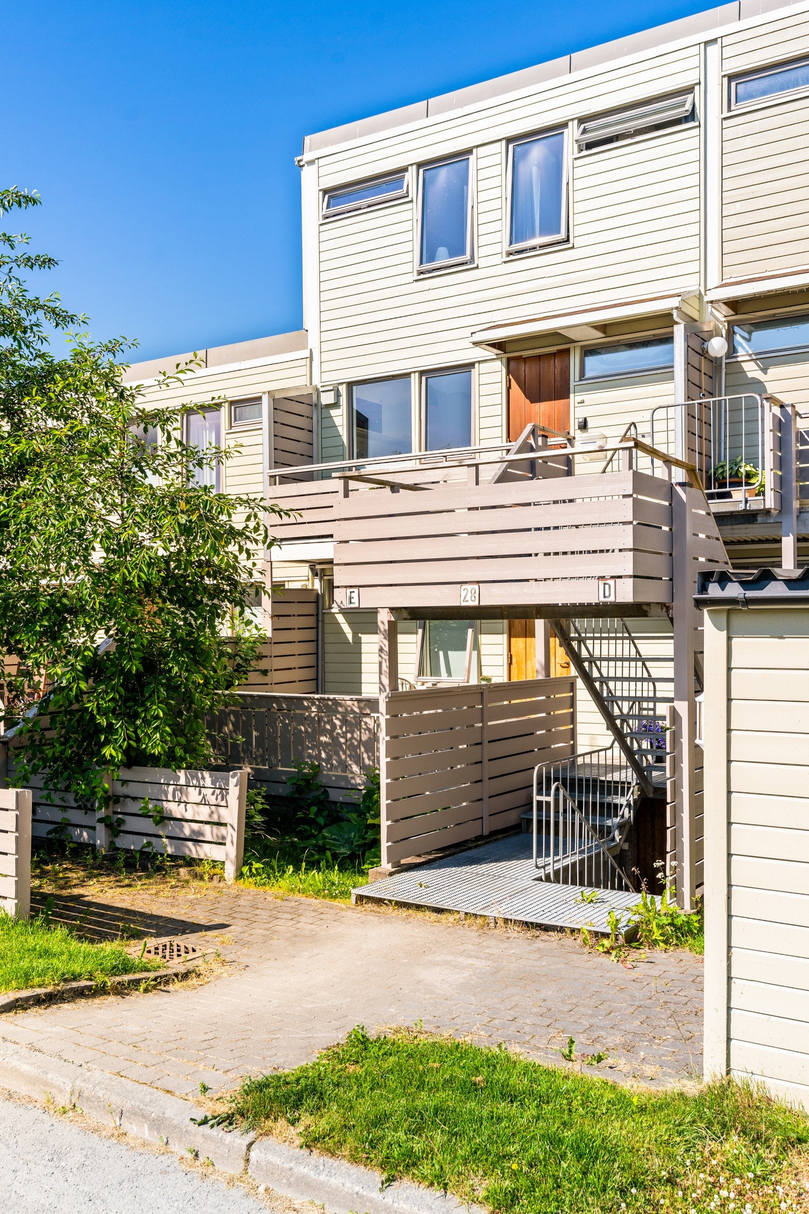 Fra bakkeplan tar man trappen opp til leilighetens østvendte inngangsparti. Galleribilde