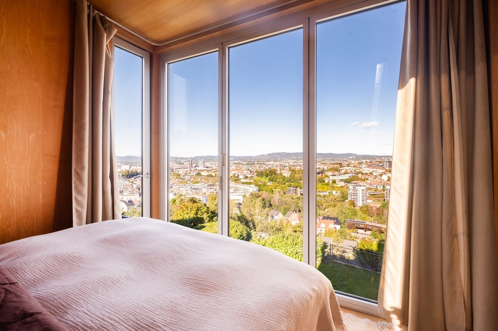 Store foldedører i glass som gjør at du kan nye den spektakulære utsikten fra sengen. Galleribilde