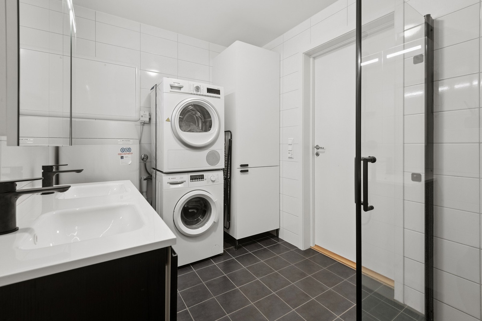 Flislagt bad med opplegg for vaskemaskin. Badet er flislagt og har varmekabler. Galleribilde