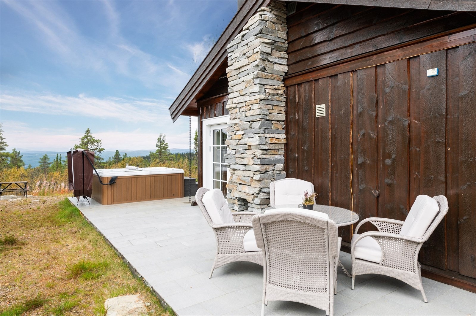 Den delen av terrassen vender mot syd. Utvendig pipeløp med flott naturstein. Galleribilde