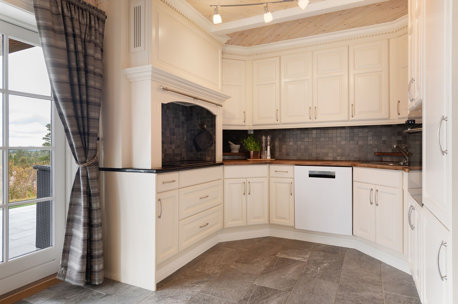 Innredningen har lyse profilerte fronter, benkeplate av stein og heltre med nedfelt oppvaskkum. Galleribilde