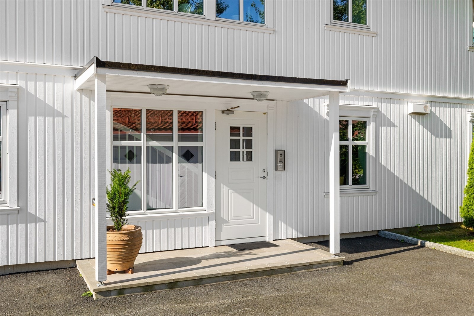 Inngangspartiet er velstelt og innbydende, med et ryddig uttrykk som gjenspeiler resten av eiendommen. Porttelefon gir både sikkerhet og enkel tilgang for gjester. Galleribilde