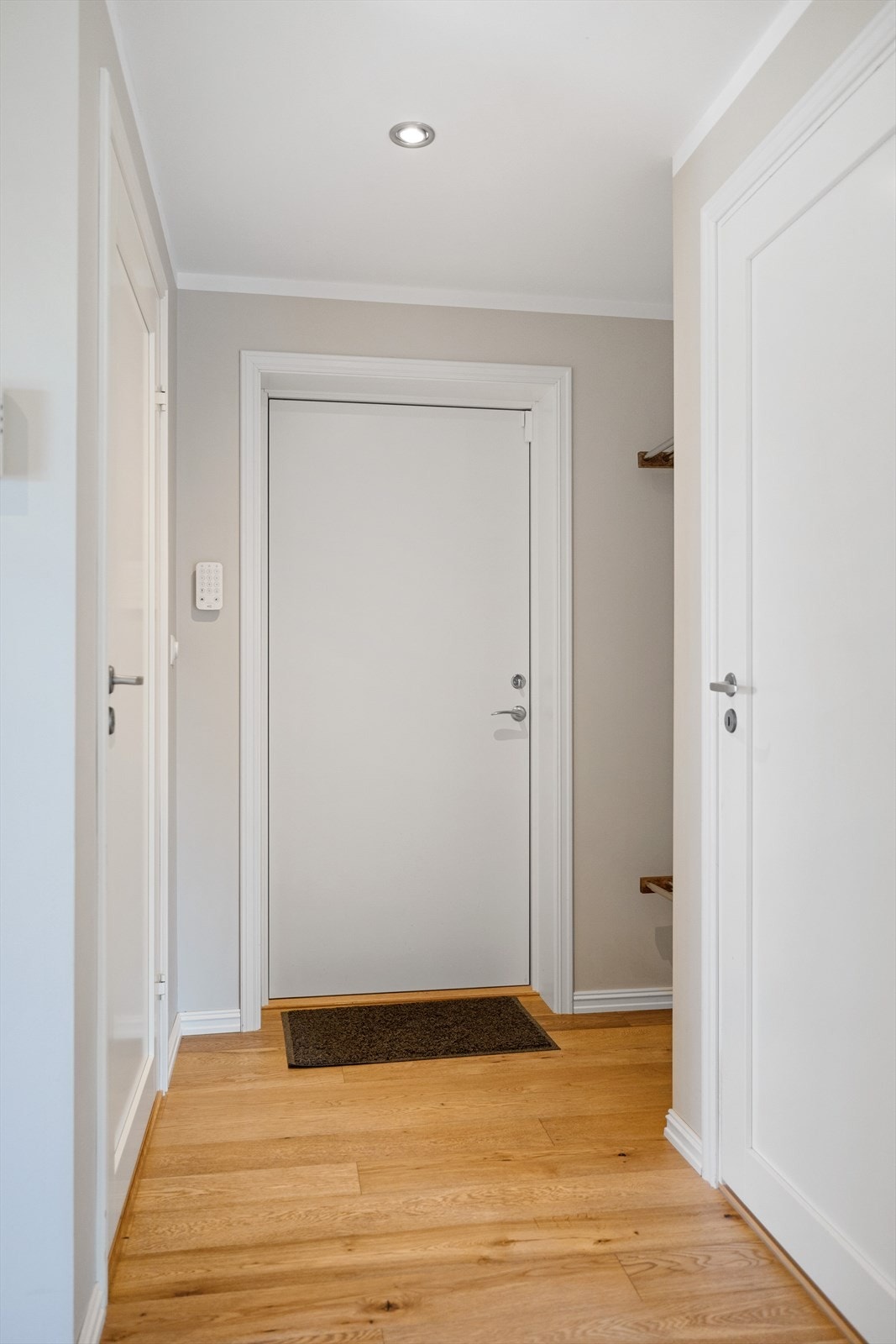 Spotter i taket sørger for behagelig belysning og fremhever de gjennomtenkte detaljene. En stilfull entré som kombinerer funksjonalitet og estetikk på en elegant måte. Galleribilde