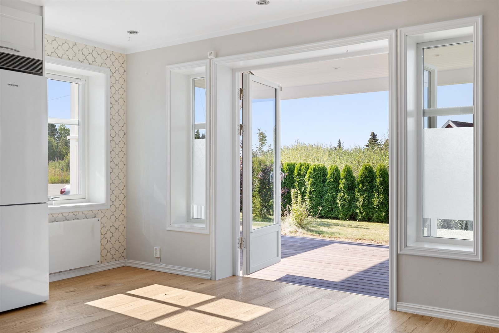 Fra kjøkkenet er det direkte utgang gjennom dobbel terrassedør til en solrik og innbydende terrasse - perfekt for morgenkaffen eller hyggelige måltider utendørs. Galleribilde