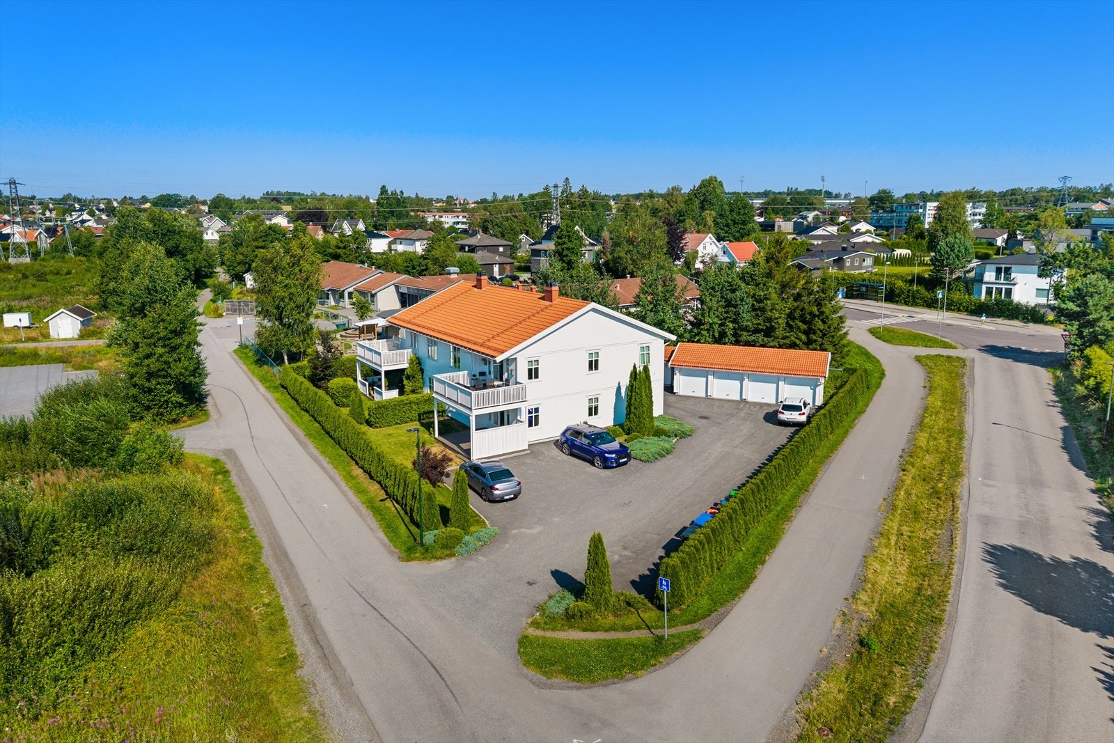 Eiendommen ligger på en flat og solrik felles eiertomt som er vakkert opparbeidet med velstelt plen, frodige busker og innrammende hekk. Galleribilde