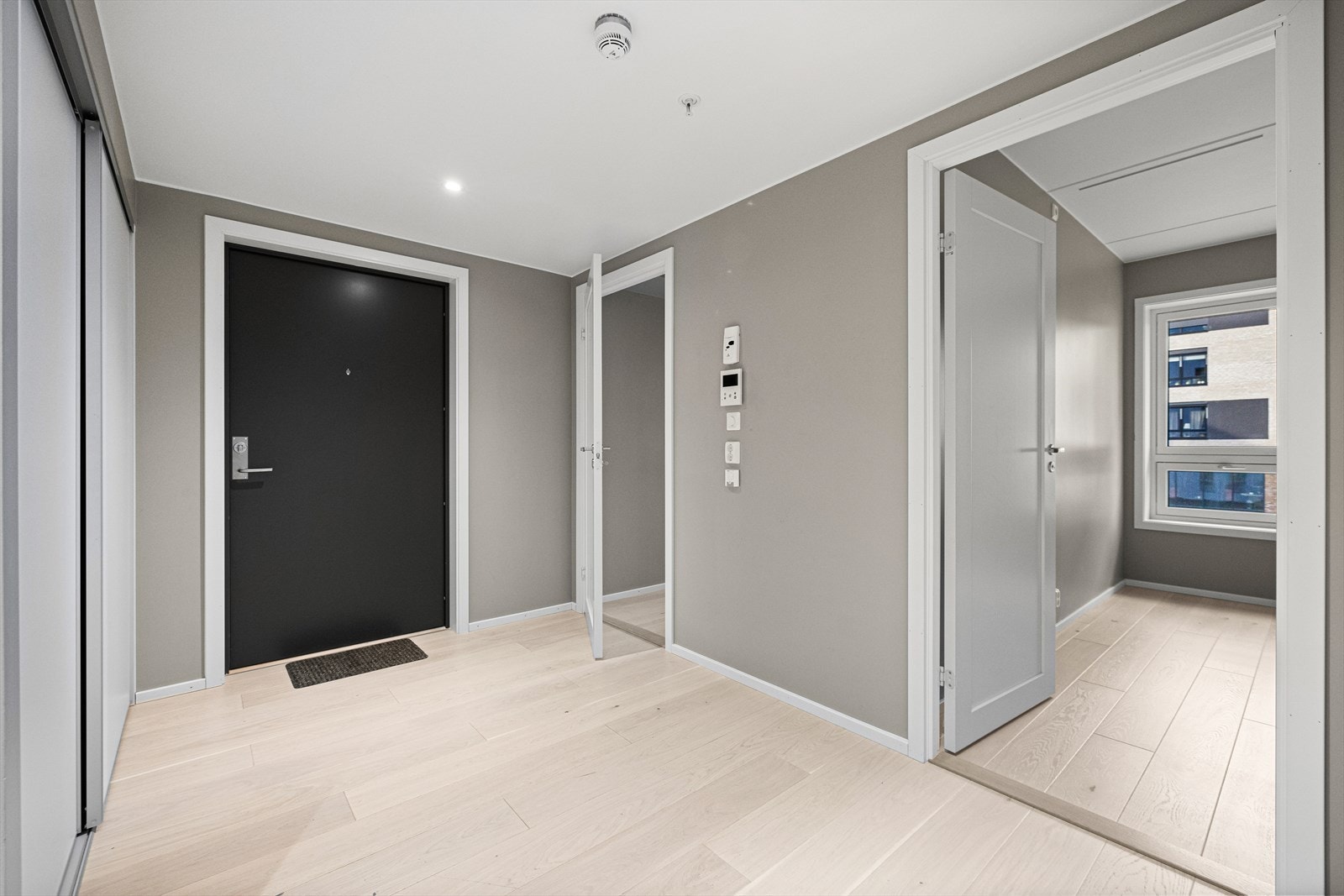 Lys og fin entré med skyvedørsgarderobe og porttelefon Galleribilde