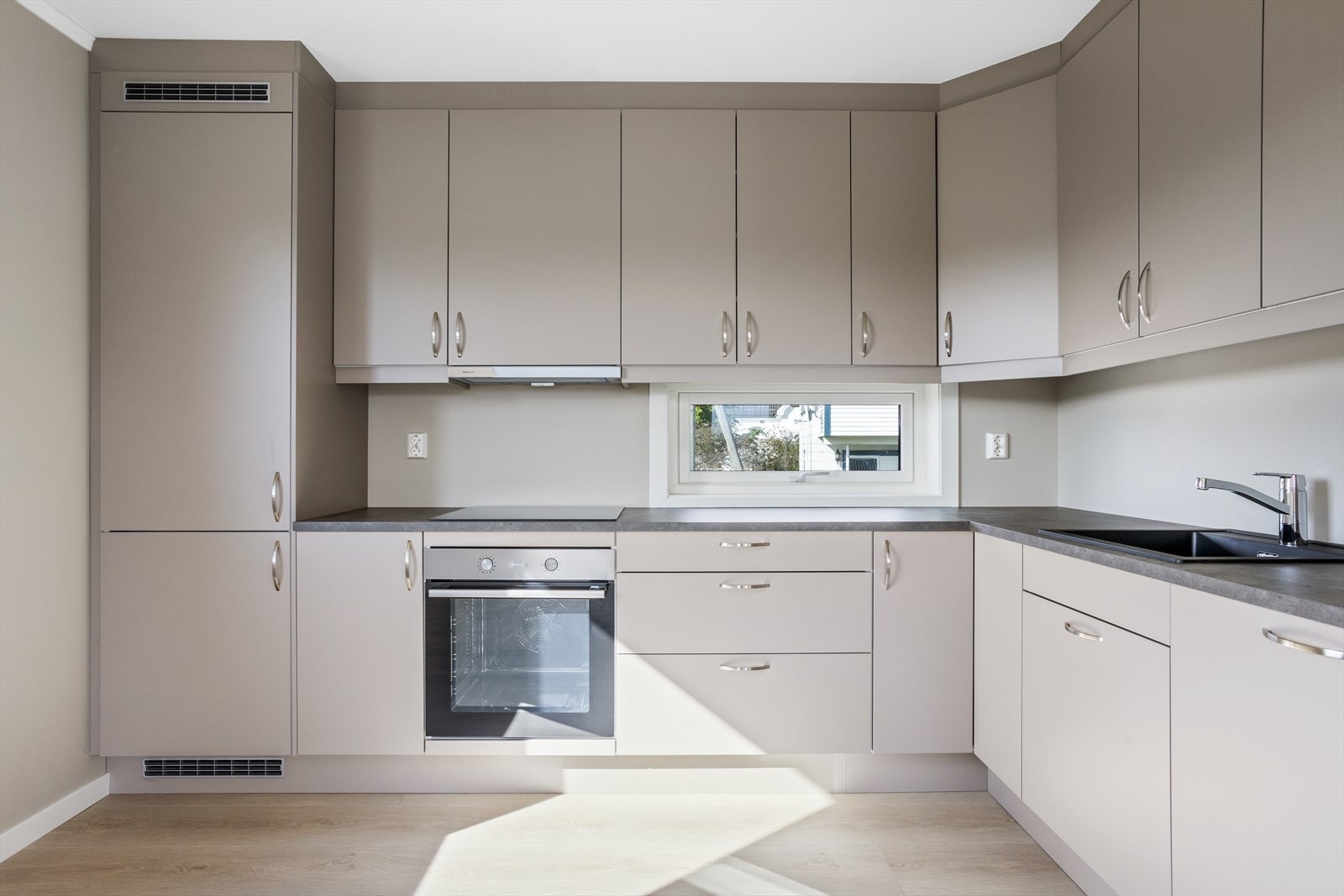 Lekker og moderne kjøkkeninnredning med integrerte hvitevarer, og god skap- og benkeplass. (Bilde av naboleilighet med speilvendt planløsning) Galleribilde