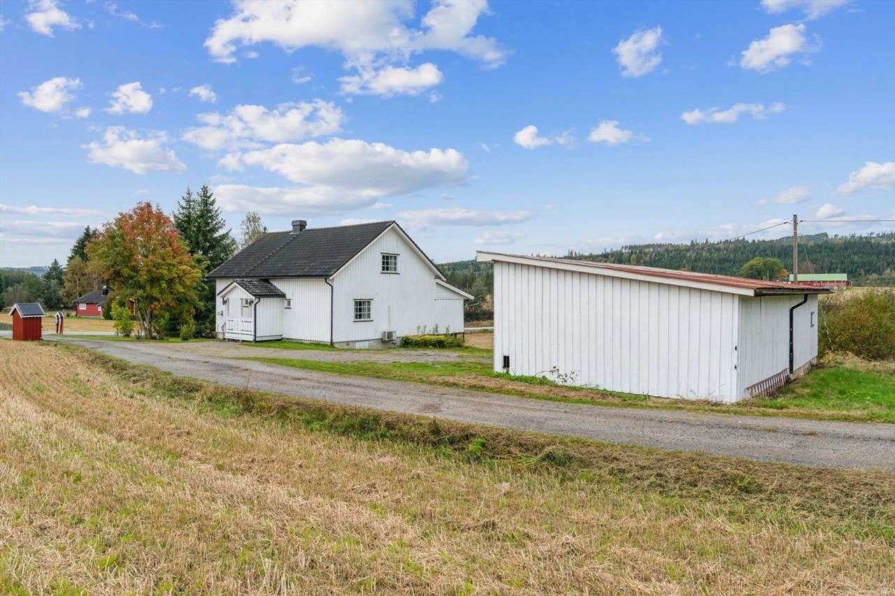 Eiendommen har en gruslagt gårdsplass og en separat garasjebygning. Galleribilde