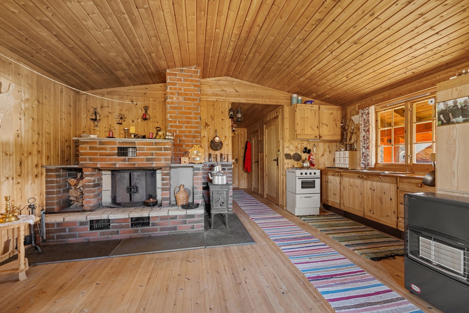 I stuedelen er det både peis og lukket peisovn som sikrer god varme på kalde høst- og vinterdager! Galleribilde