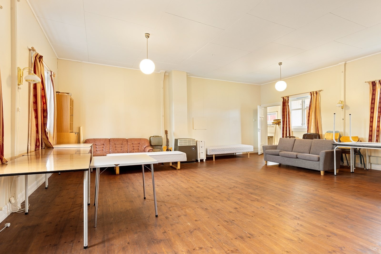 Menighetssal med beiset furugulv på gulv og malte plater på vegger. Galleribilde