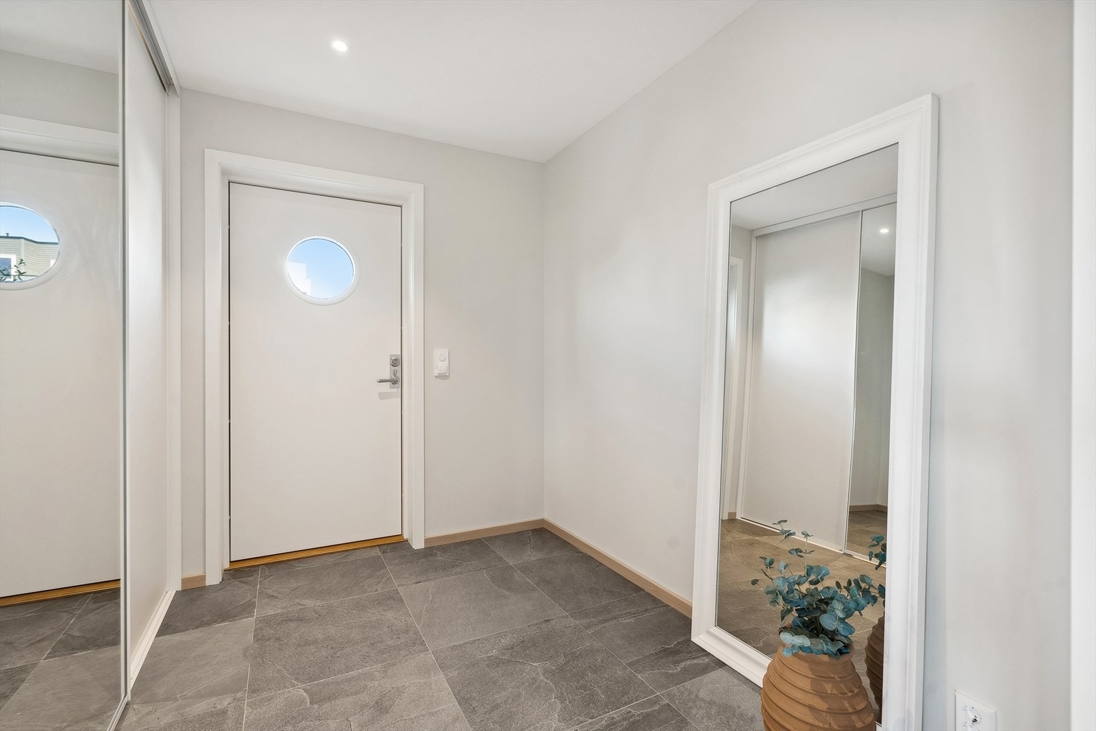 Romslig entré med skyvedørsgarderobe. Galleribilde