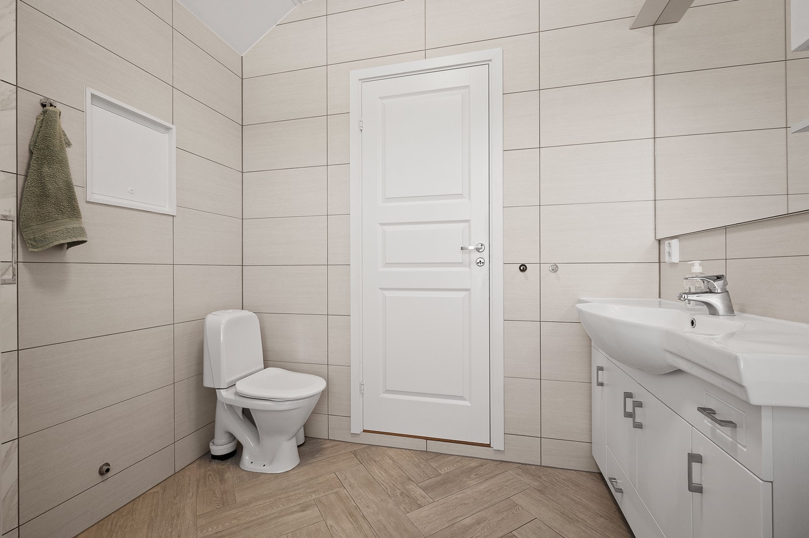 Badet i 2 etasje med gulvmontert toalett, enkel servant og dusjkabinett Galleribilde