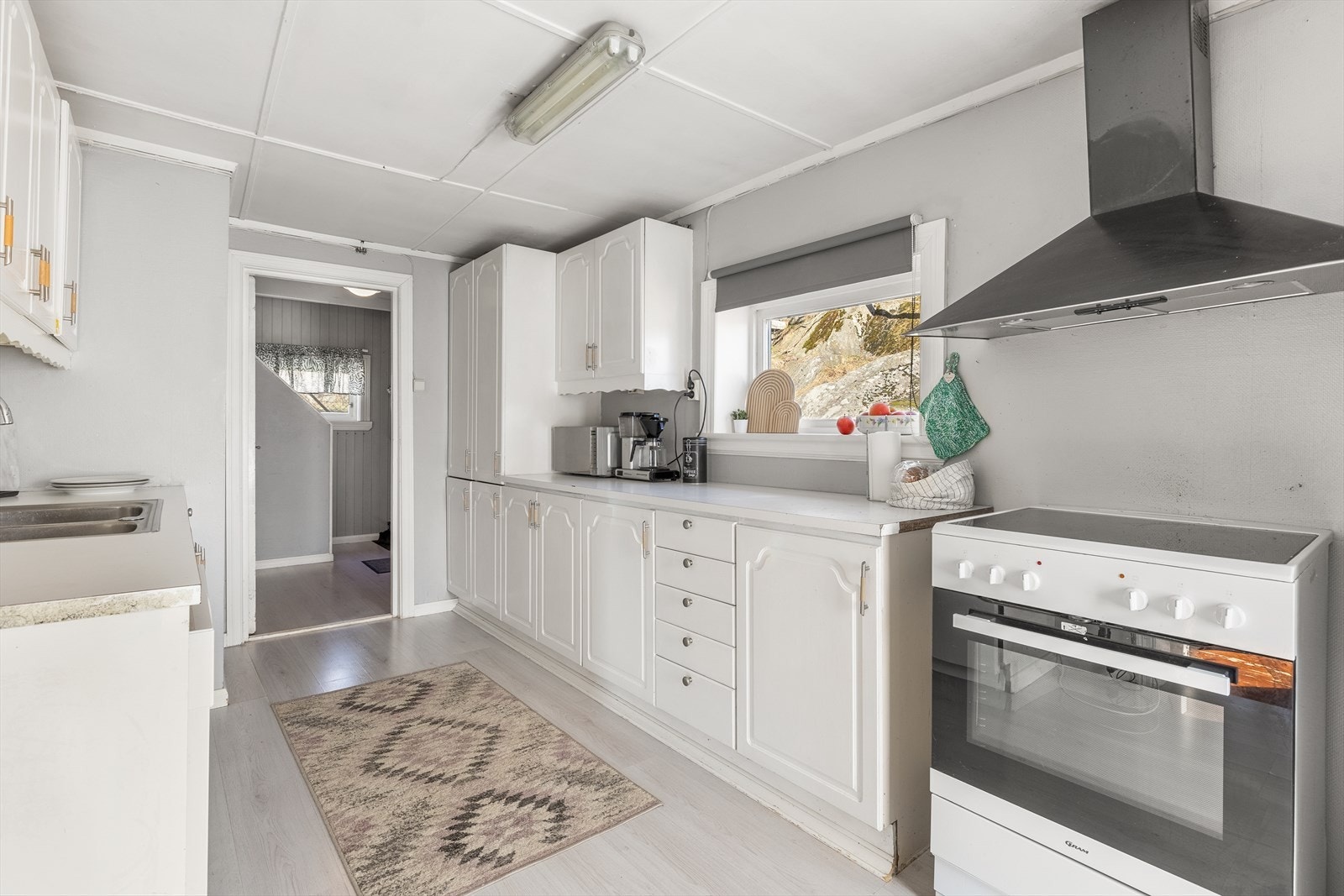 Lys kjøkkeninnredning med grei skap og benkeplass Galleribilde