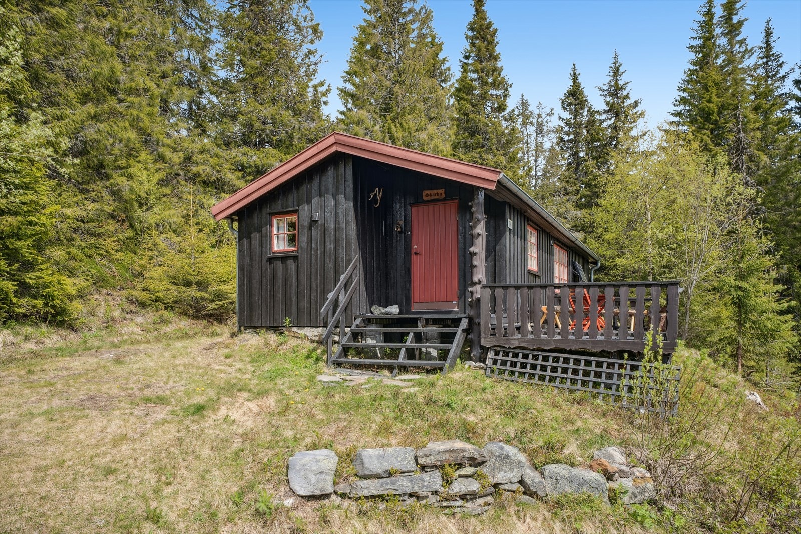 Flat og skrånet tomt delvis opparbeidet med grøntarealer og ellers naturtomt. 2 biloppstillingsplasser ved hytta. Galleribilde