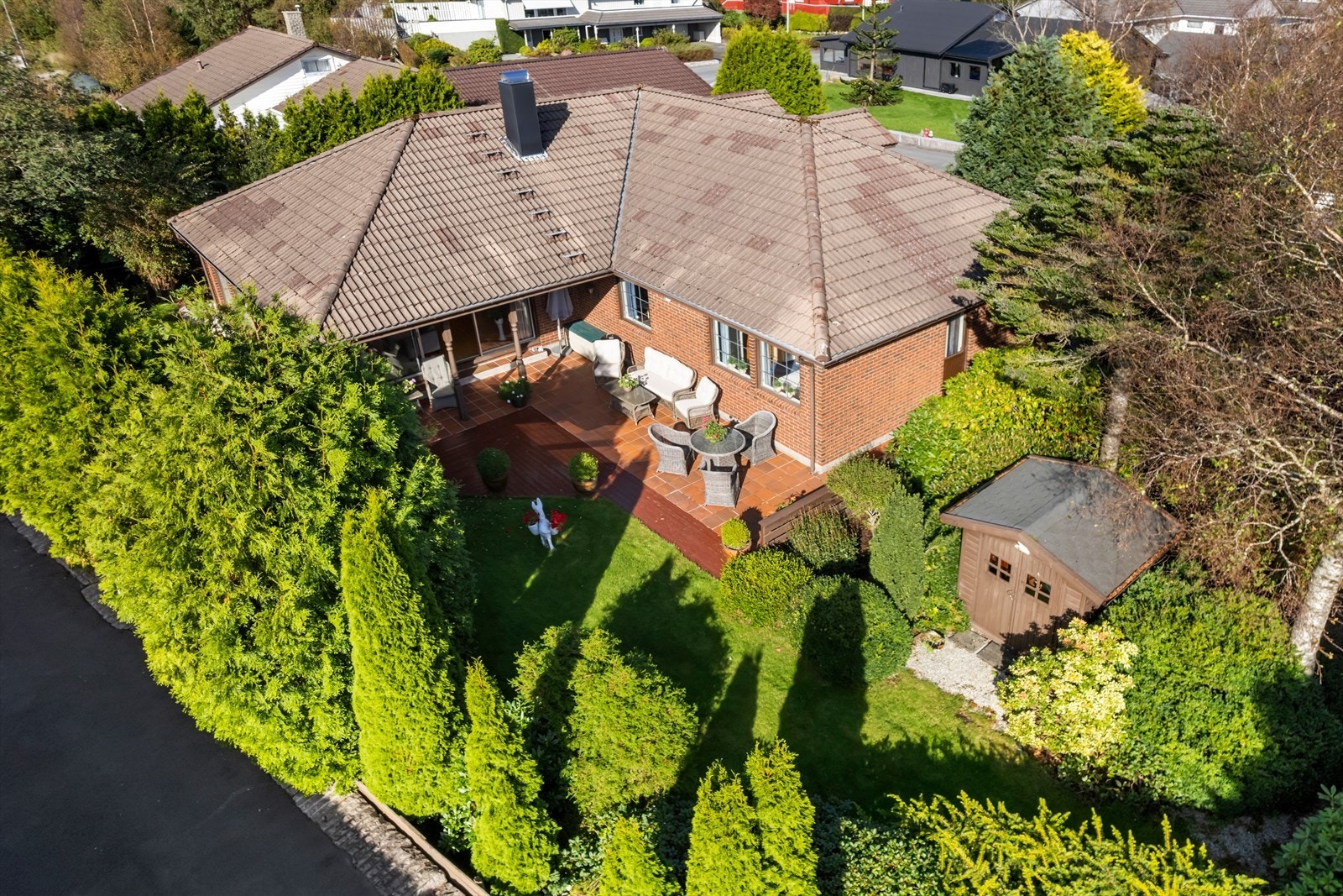 Eiendommen ligger på en fint opparbeidet tomt med vakker beplantning, bestående av blomster, busker og trær, noe som skaper en harmonisk og innbydende atmosfære. Galleribilde