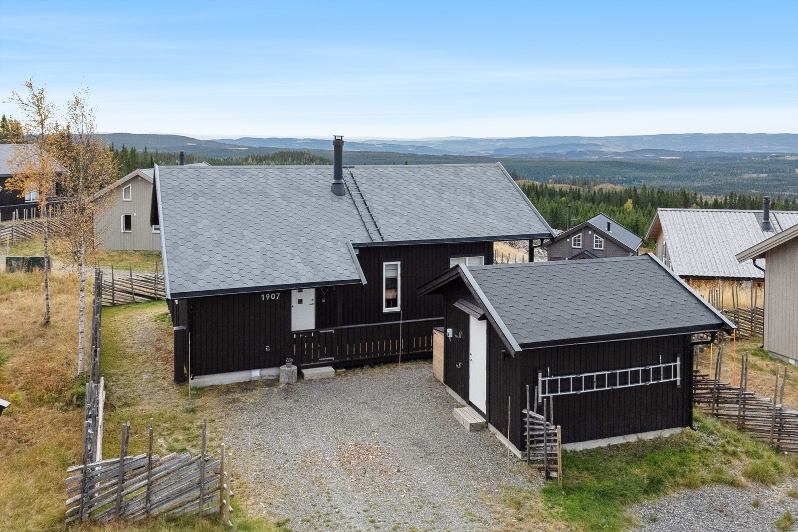 Gruset innkjørsel til hytta og romslig frittstående bod. Galleribilde