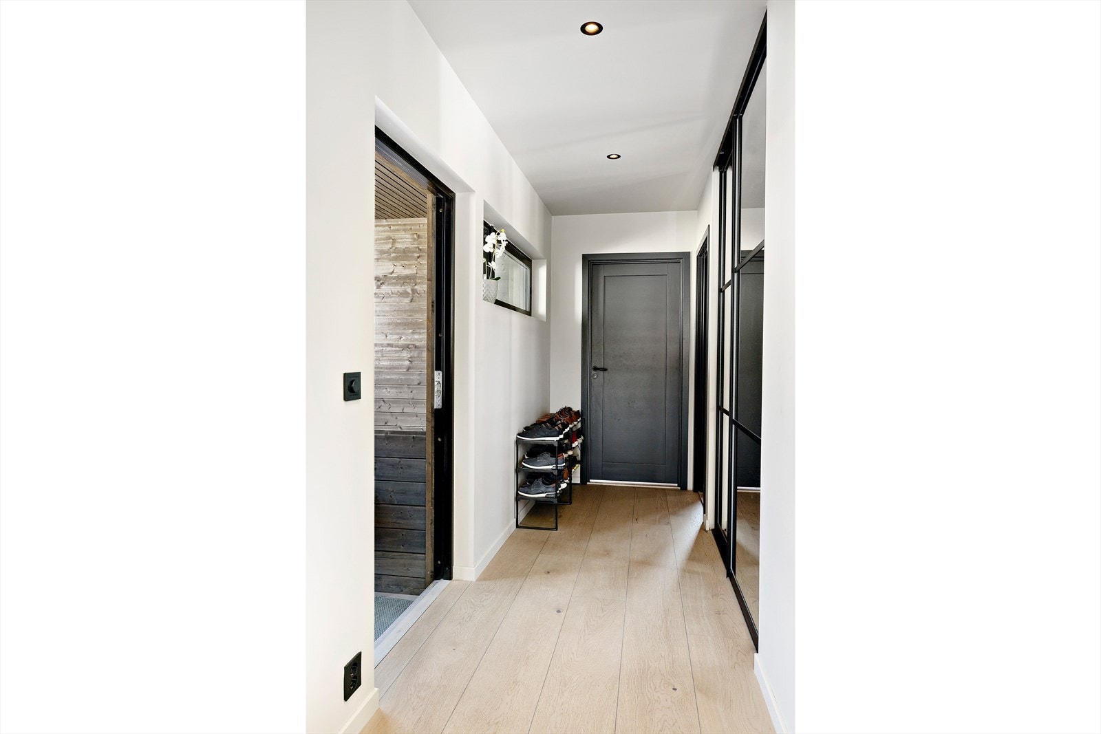 Lys entré med god plass til sko og yttertøy. Skyvedørsgarderobe med speilfronter. Galleribilde