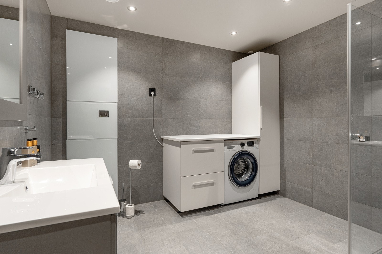 Hovedbadet er romslig og innredet med dusjnisje, servantinnredning, speil og wc, samt en flott innredning med opplegg for vaskemaskin. Galleribilde