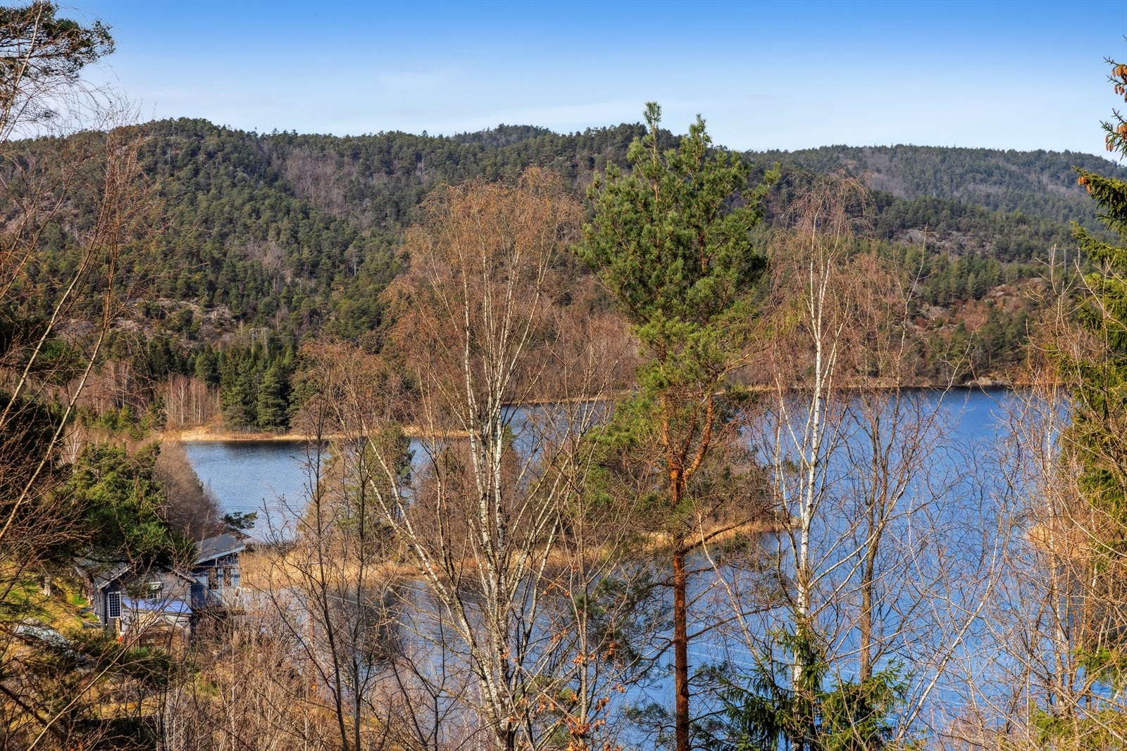 Nydelig utsikt over Hemningsvannet fra hytta. Synlige trær mellom hytten og vannet er på egen tomt og kan fjernes om ønskelig av ny eier. Galleribilde