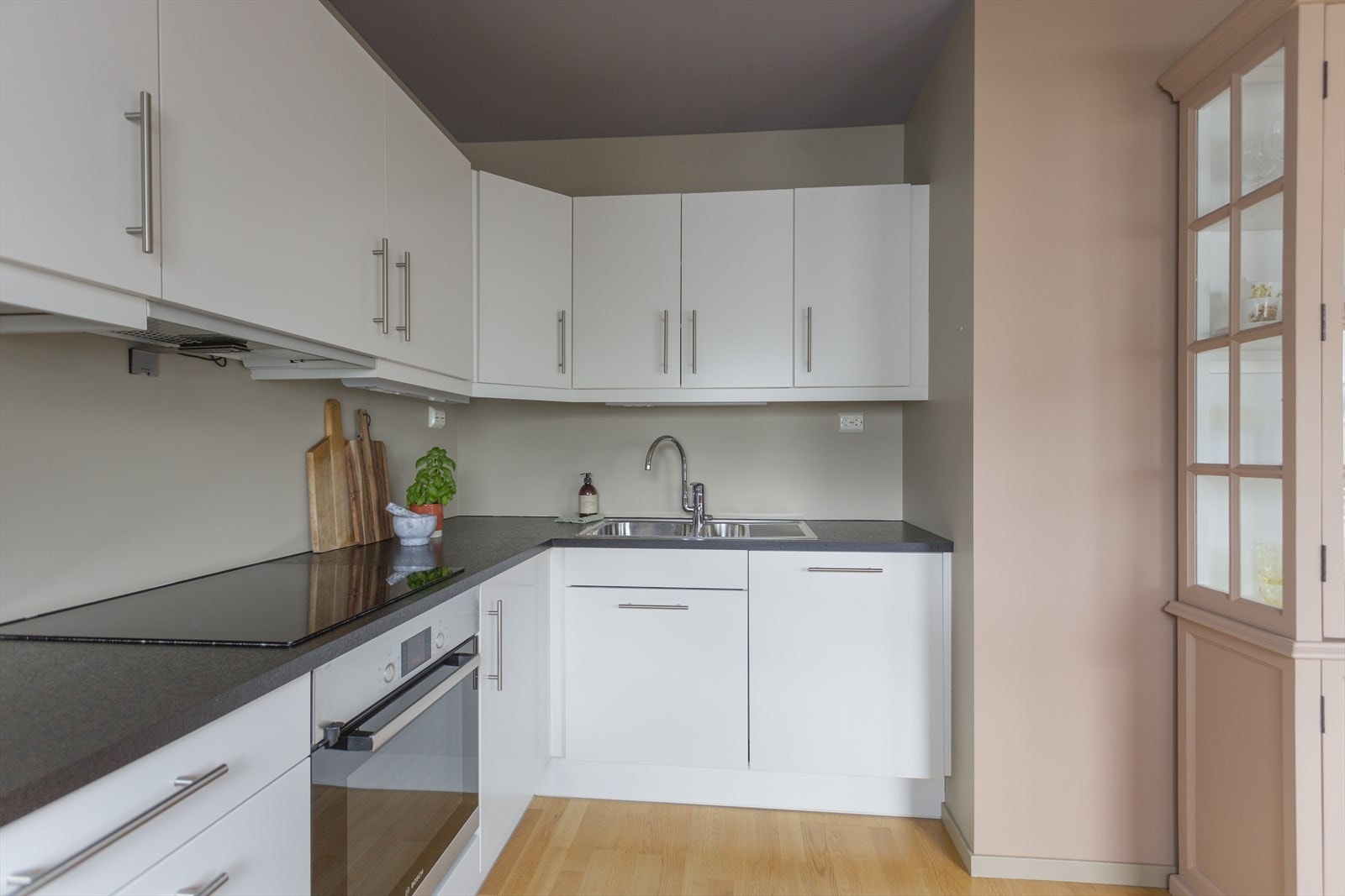 Laminerte benkeplater med dobbel oppvaskkum i rustfritt stål. Stekeovn, platetopp og oppvaskmaskin er integrert i kjøkkenet og det er plass til frittstående kjøleskap. Galleribilde