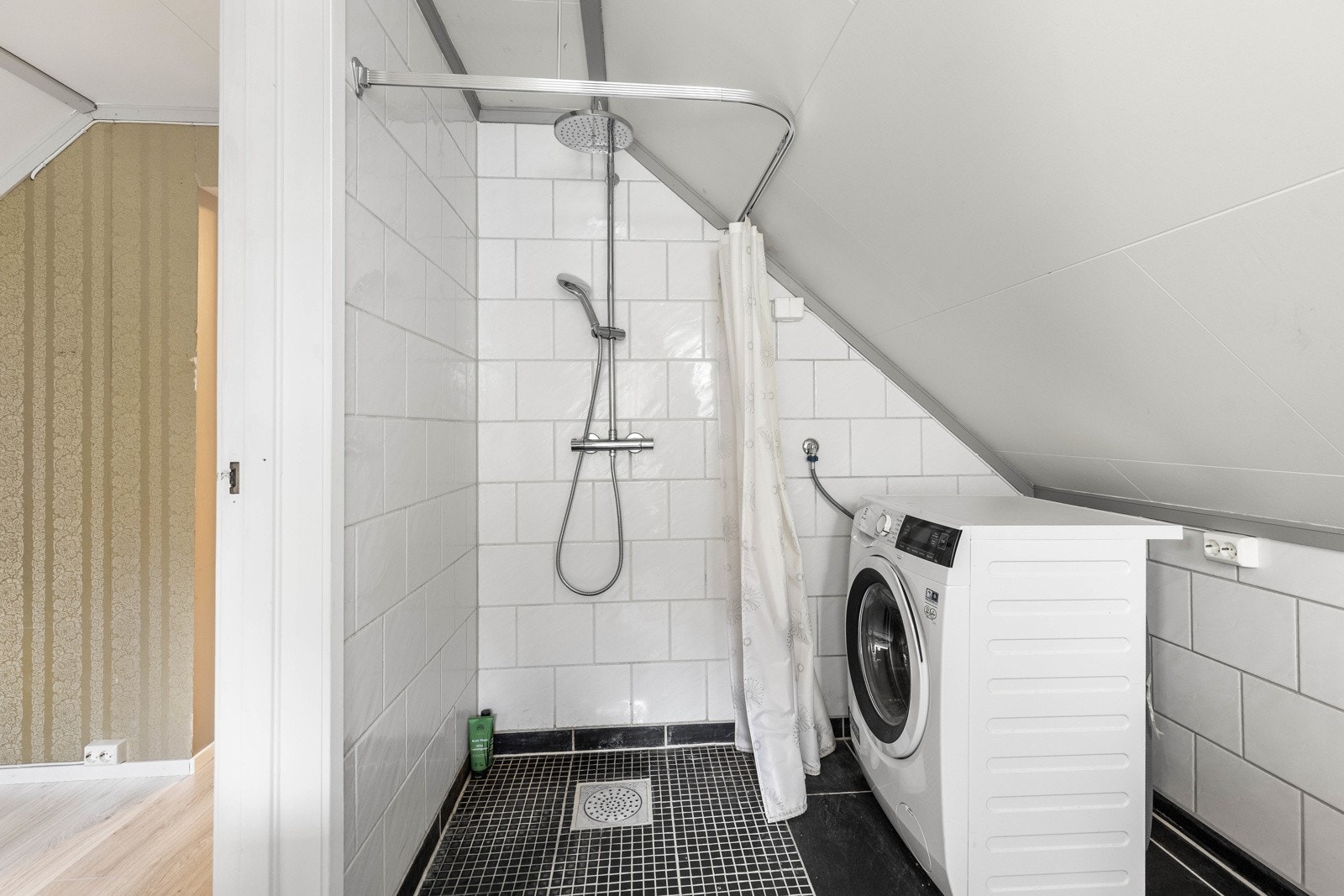 Flislagt bad med dusj og opplegg for vaskemaskin. Galleribilde