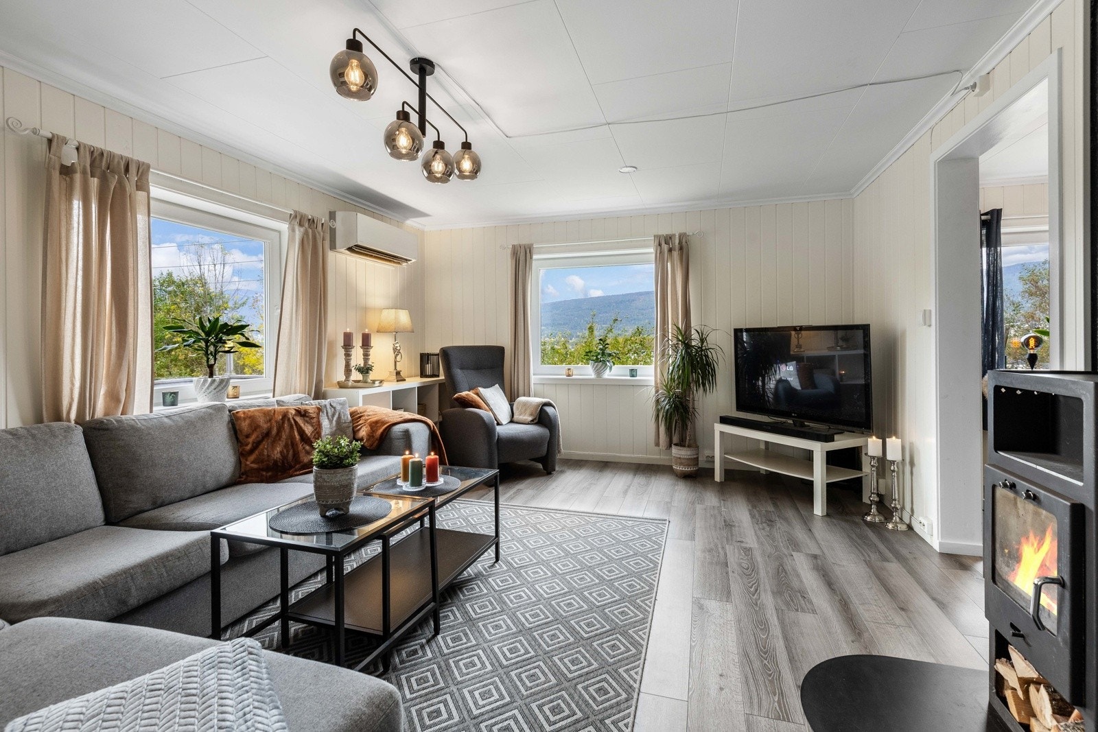 Moderne og hyggelig stue med peisovn og direkte utgang til solrik uteplass. Galleribilde