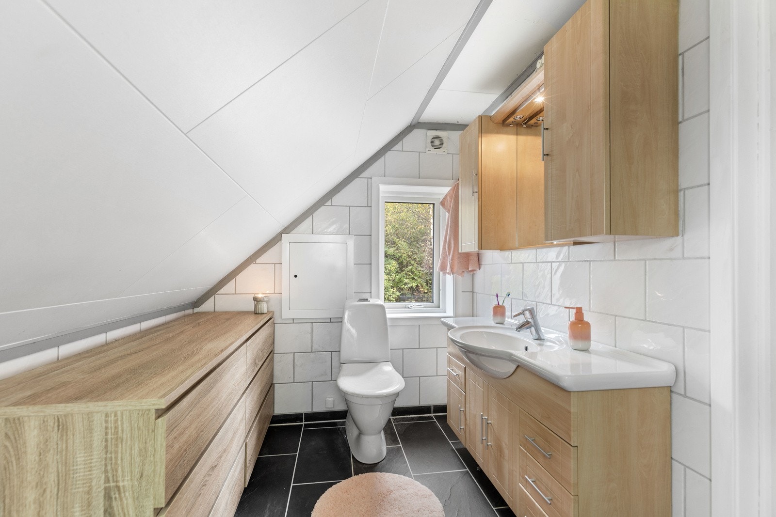 Bad med praktisk løsning, lyse flater og god oppbevaringsplass. Galleribilde