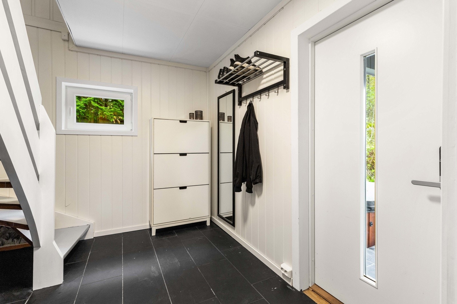 Lys og praktisk felles inngang med flislagt gulv og plass til oppbevaring. Galleribilde