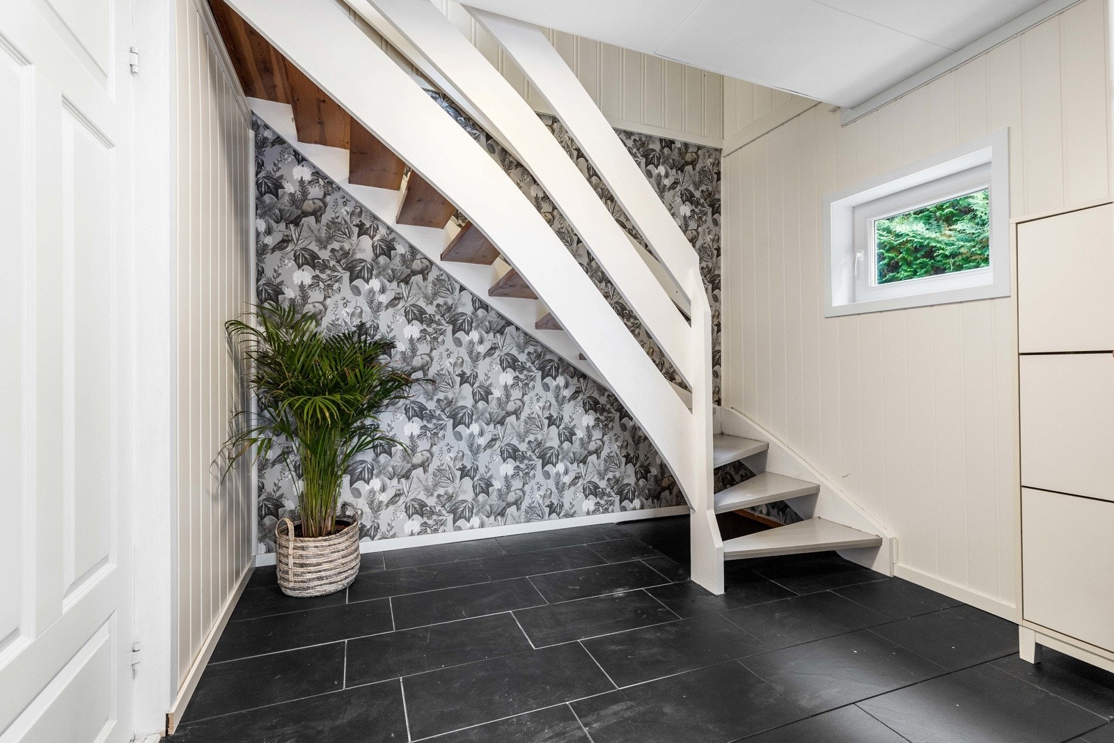 Lys og innbydende gang med flislagt gulv og trapp opp til hybelen. Galleribilde