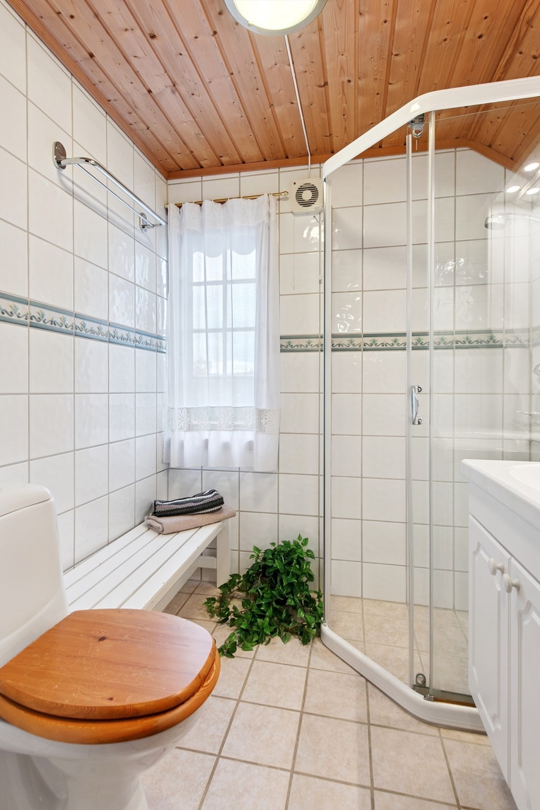 Badet i 2. etasje er flislagt og utstyrt med dusjhjørne, toalett og servant. Galleribilde